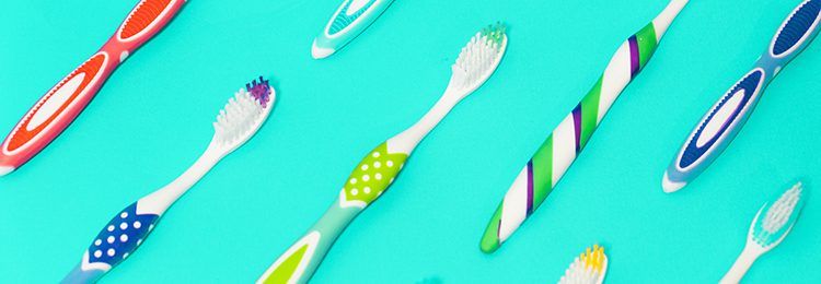 a variety of tooth brushes on a blue background